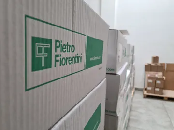 Vedere de aproape a unor cutii stivuite cu sigla verde Pietro Fiorentini, cu fundalul ușor estompat.
