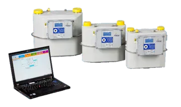 Trei contoare de gaz cu membrană, de culoare gri și de mărimi diferite, cu afișaje electronice pe partea frontală, așezate lângă un laptop deschis.